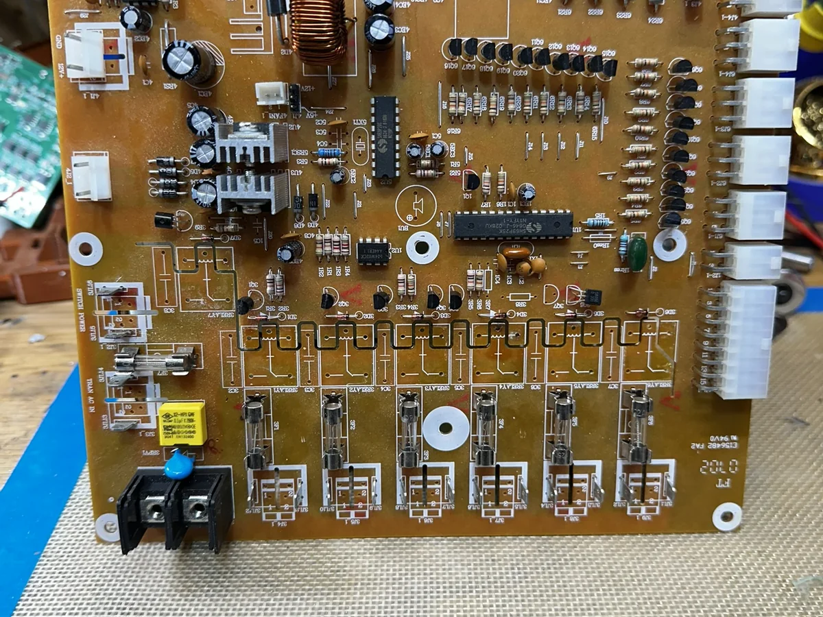 Control board on a repair bench with relays removed for service