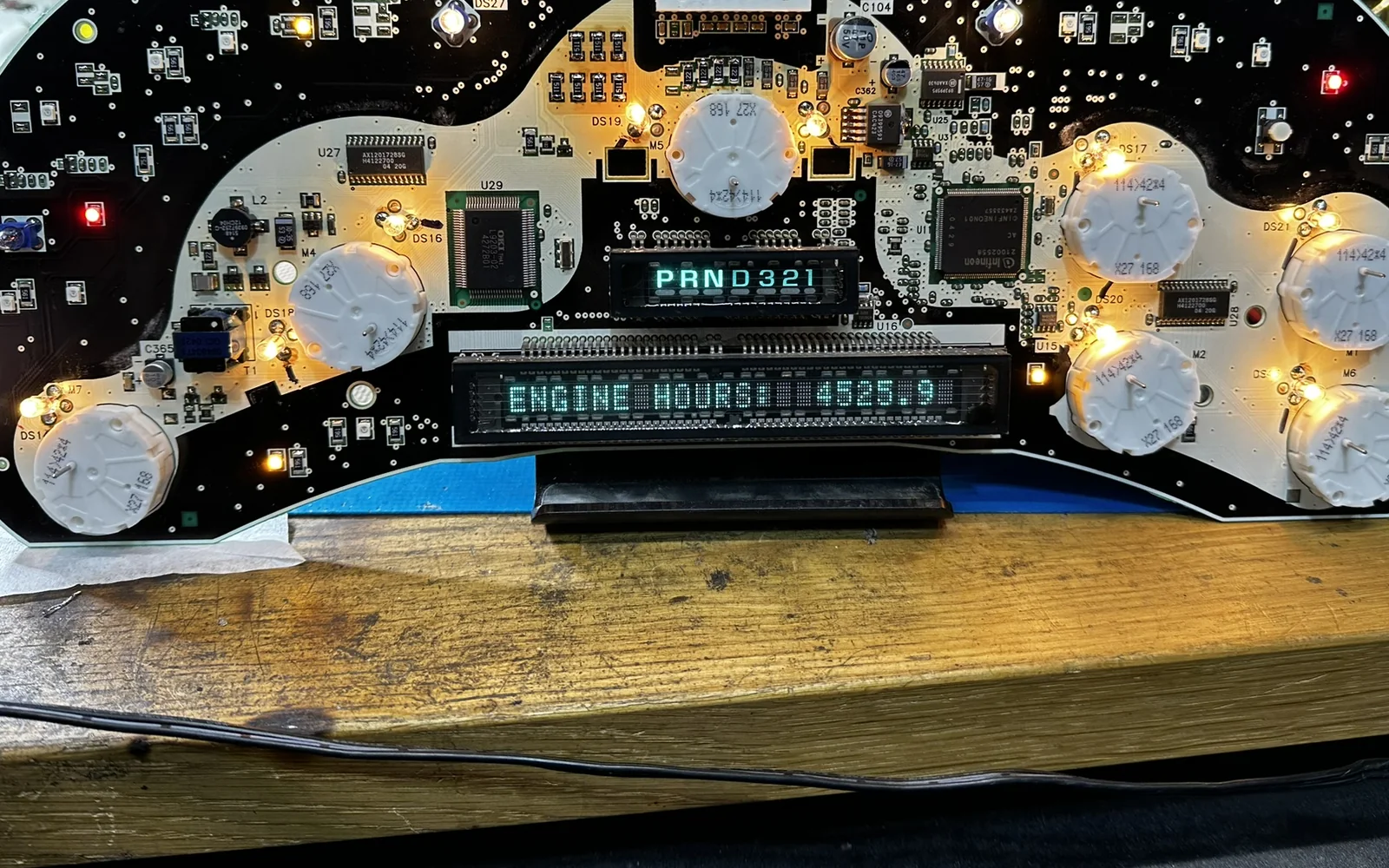 Open automotive instrument cluster circuit board illuminated during a bench test